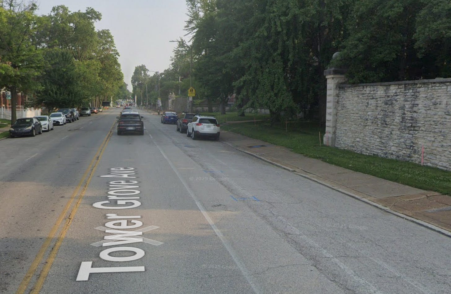 A photo of Tower Grove Ave in St. Louis showing a road in poor shape with faint lines for the bike lane. A photo of Tower Grove Ave in St. Louis showing a road in poor shape with faint lines for the bike lane.