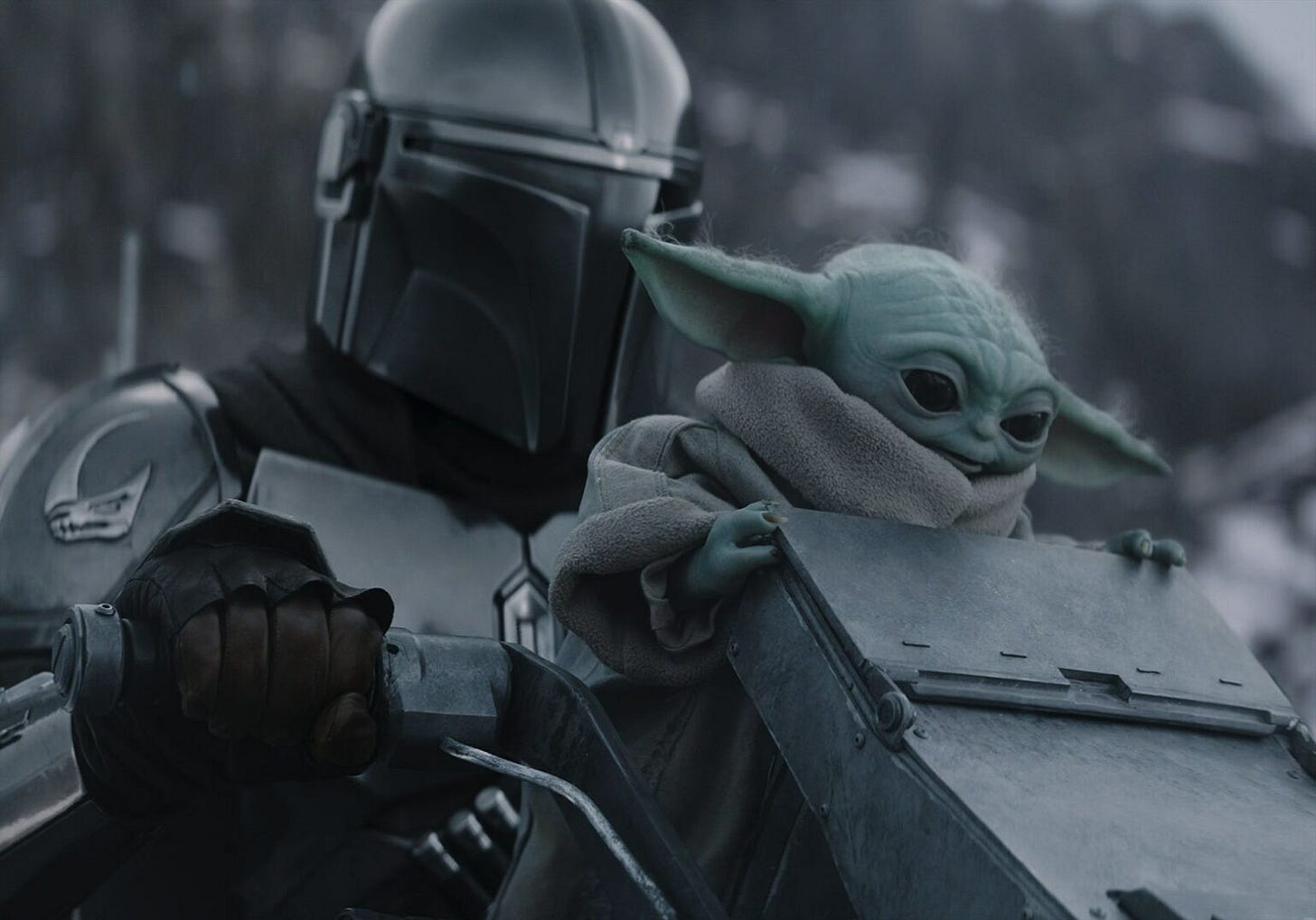 The Mandalorian and Grogu riding a quick, mechanical walker machine. The Mandalorian and Grogu riding a quick, mechanical walker machine.