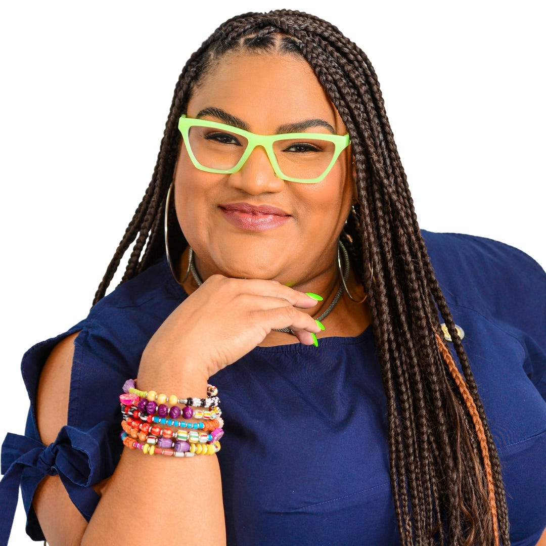 A woman with braids who's wearing bright green glasses smiles into the camera.