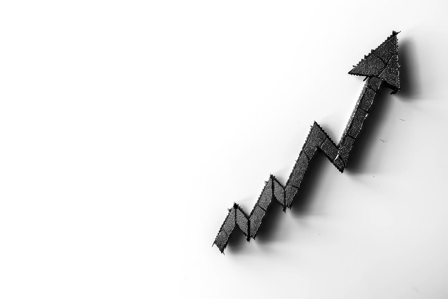 Black zigzag arrow rising upward on a white background.