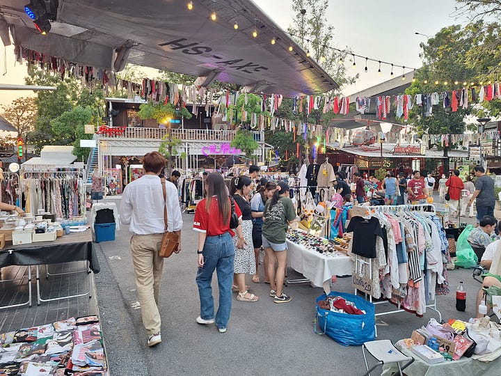 Guests relax with coffee in hand in the lush botanical garden at Victor 515. A airplane wing overhands the vintage clothing market at Chang Chiu Creative Park.
