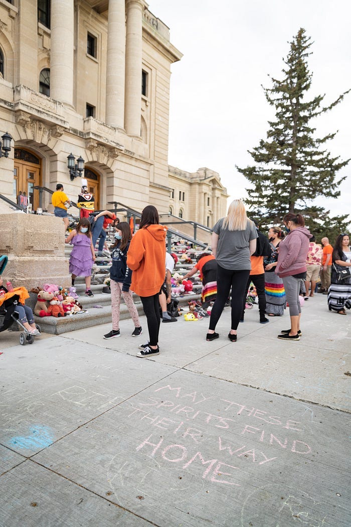 A group of First Nations people leave toys on the steps of a church, creating a memorial to the missing and murdered children of the Residential Schools. A group of First Nations people leave toys on the steps of a church, creating a memorial to the missing and murdered children of the Residential Schools.