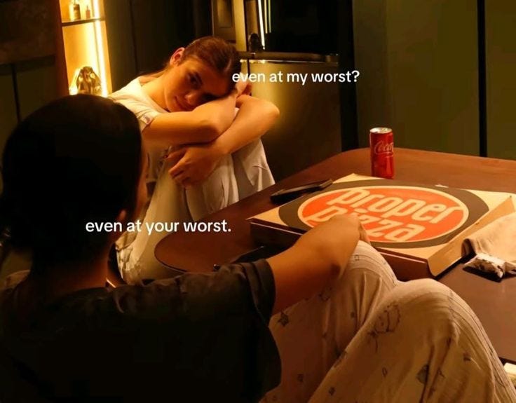 This may contain: two people sitting at a table in front of a sign that says, even at my worst? even at your worst