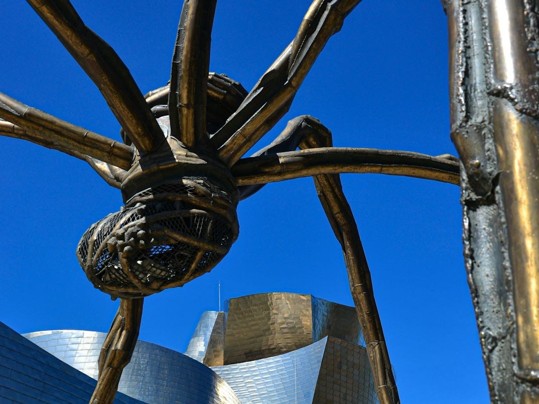 a large metal spider sculpture in front of a building