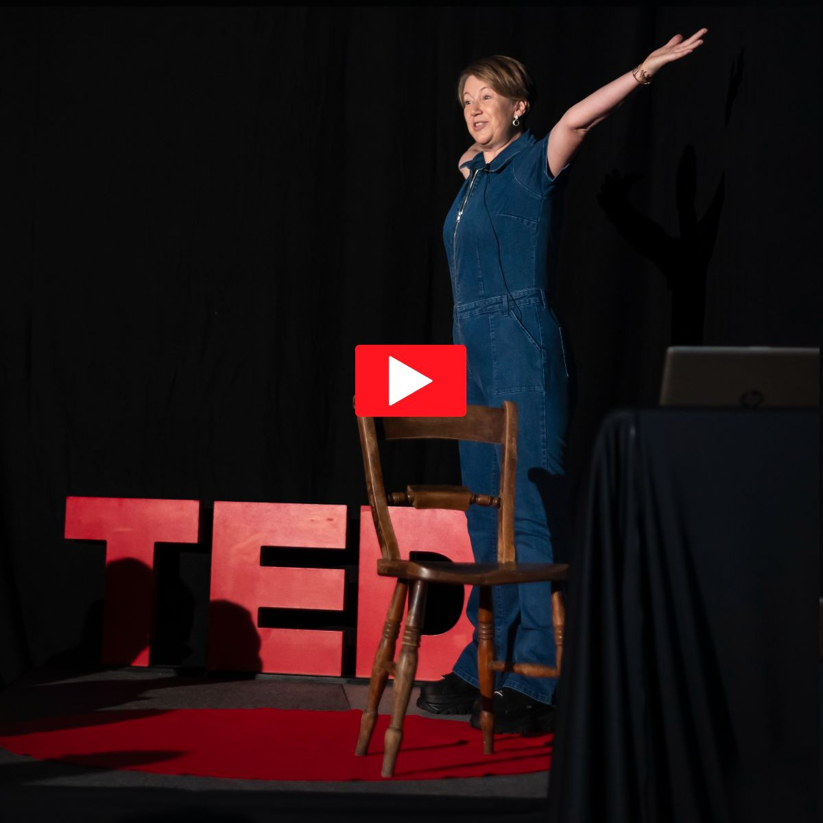 Gail on the TEDx stage, arms outstretched