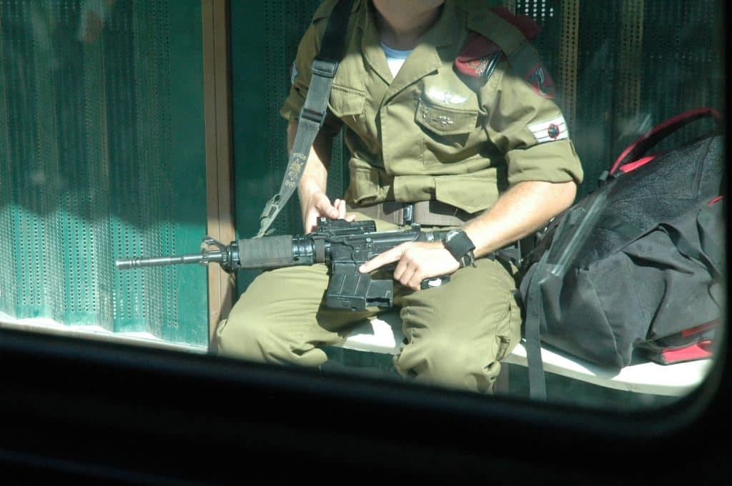 An off-duty Israeli soldier at a bus stop in Jerusalem, August 17, 2004. (Photo: Wikimedia Commons/Justin McIntosh)