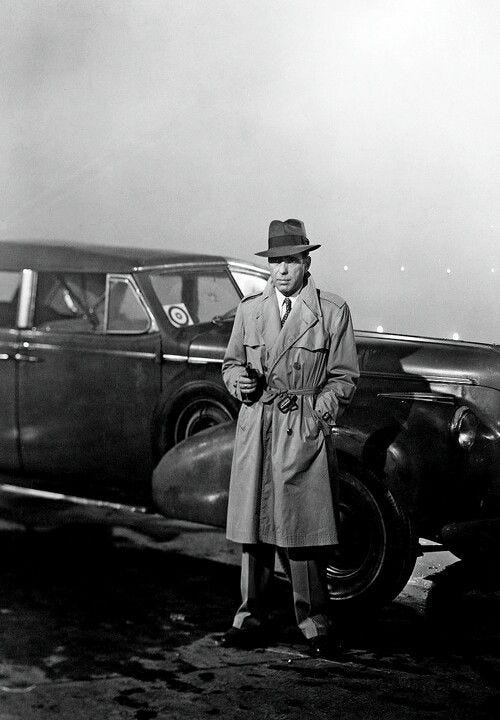 This may contain: a man in a trench coat standing next to an old car