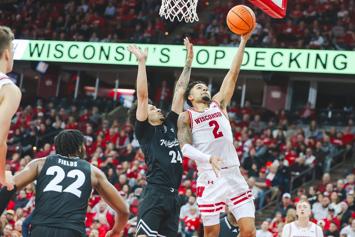 Wisconsin basketball guard Nick Boyd attempting a layup inside the Kohl Center with his left hand while being defended under the hoop
