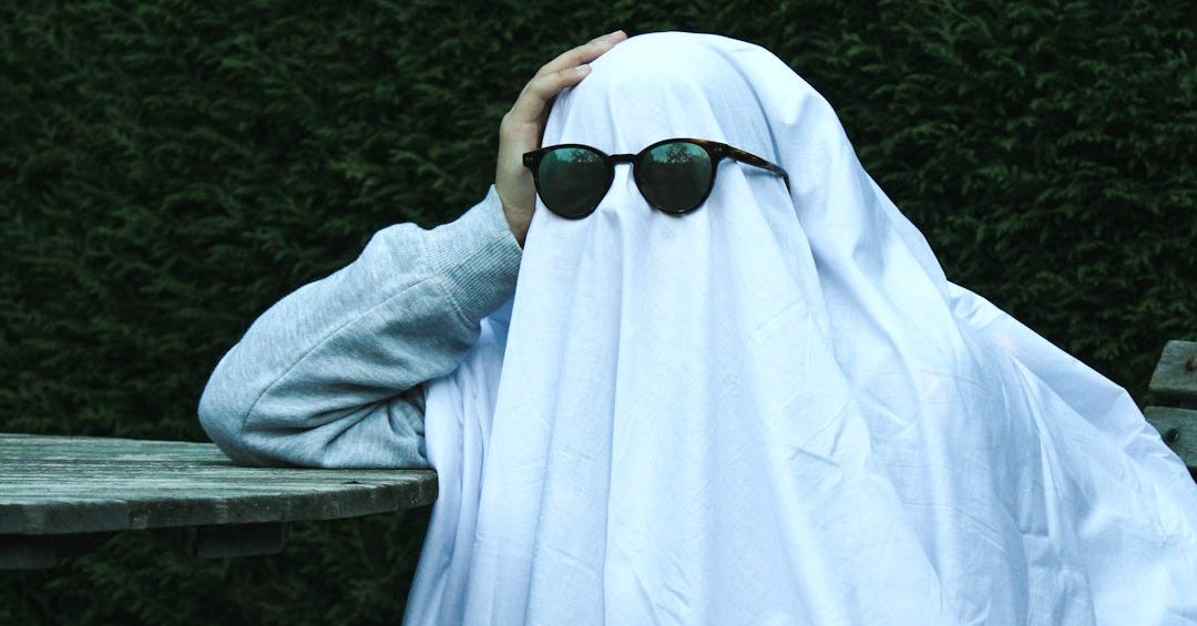 a person with sunglasses covering their face with a blanket
