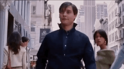a man in a blue shirt is walking down a city street with a woman . a man in a blue shirt is walking down a city street with a woman .