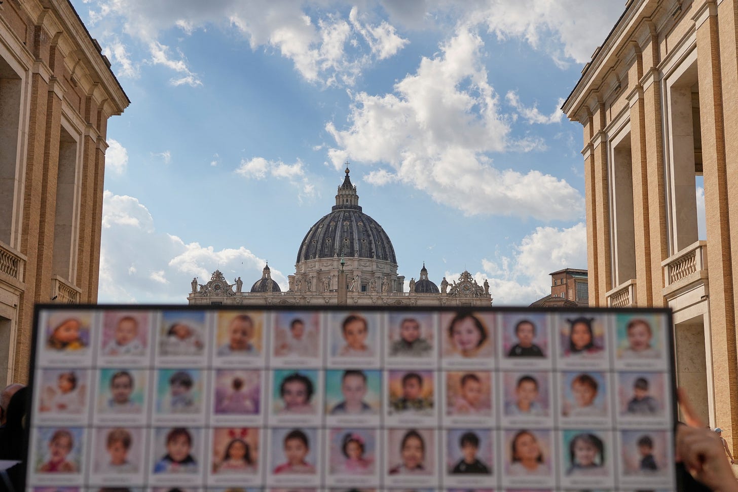 Placard of children’s photographs before St. Peter’s Basilica Placard of children’s photographs before St. Peter’s Basilica
