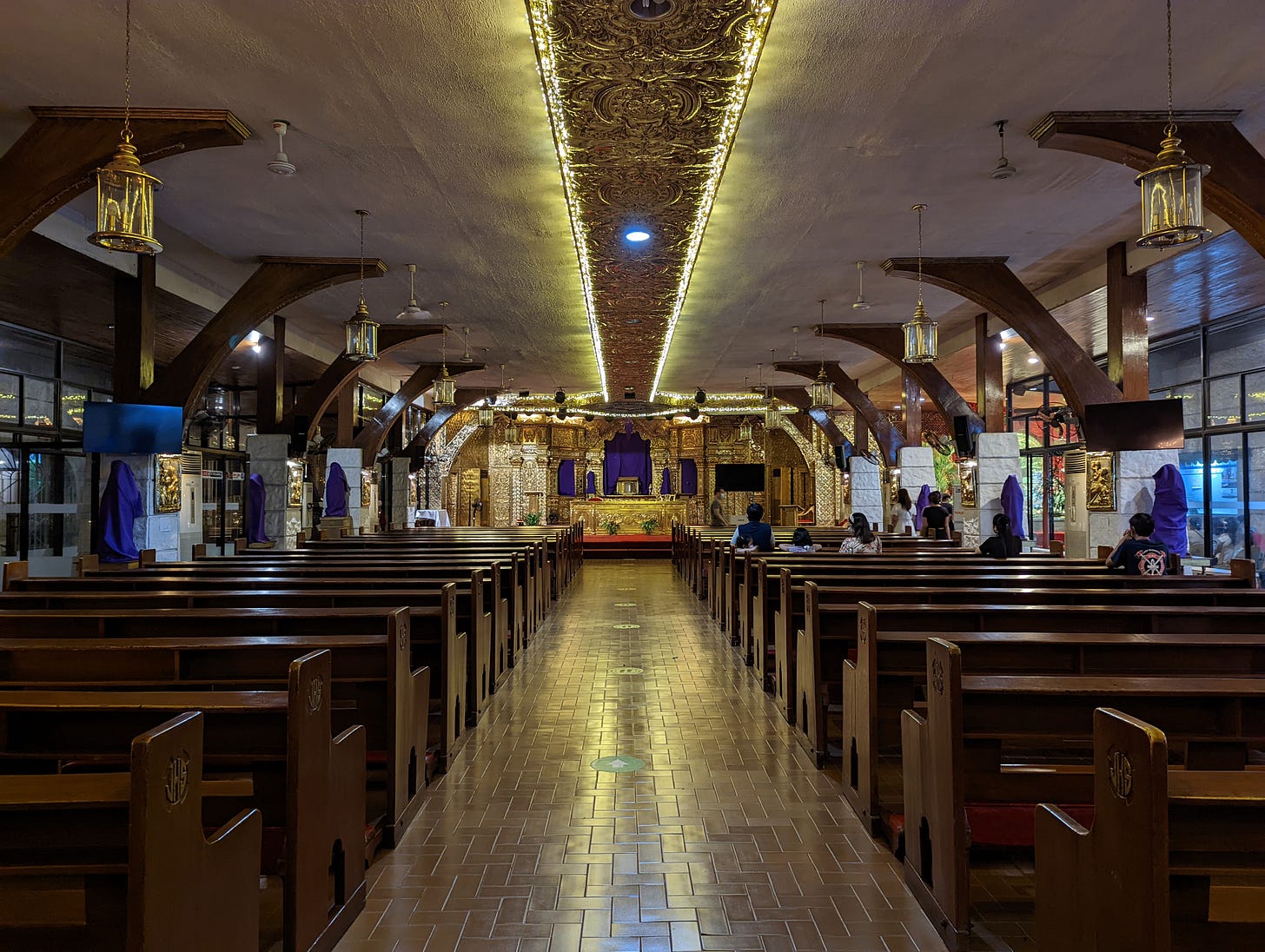 The interior of Violago Quasi-Parish showing the yellow lighting and the all-gold design of the main altar
