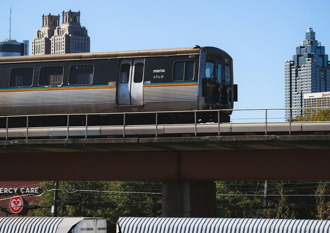a train traveling over a bridge in a city a train traveling over a bridge in a city