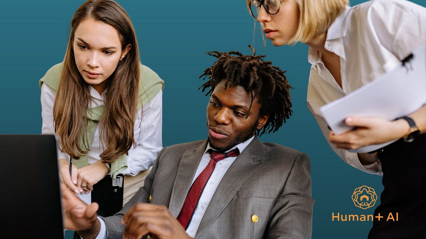 Three coworkers looking at a computer screen.