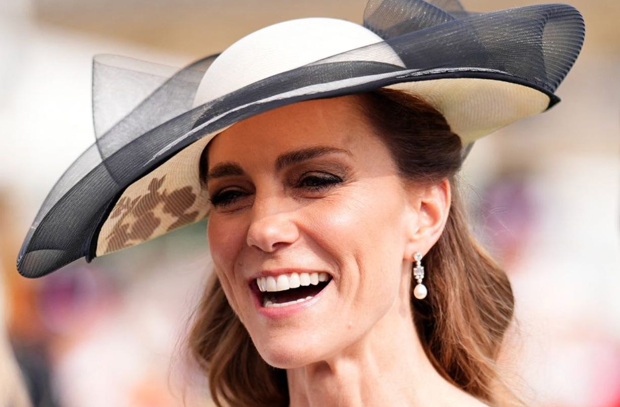 Princess Catherine smiling wearing a white and black fascinator