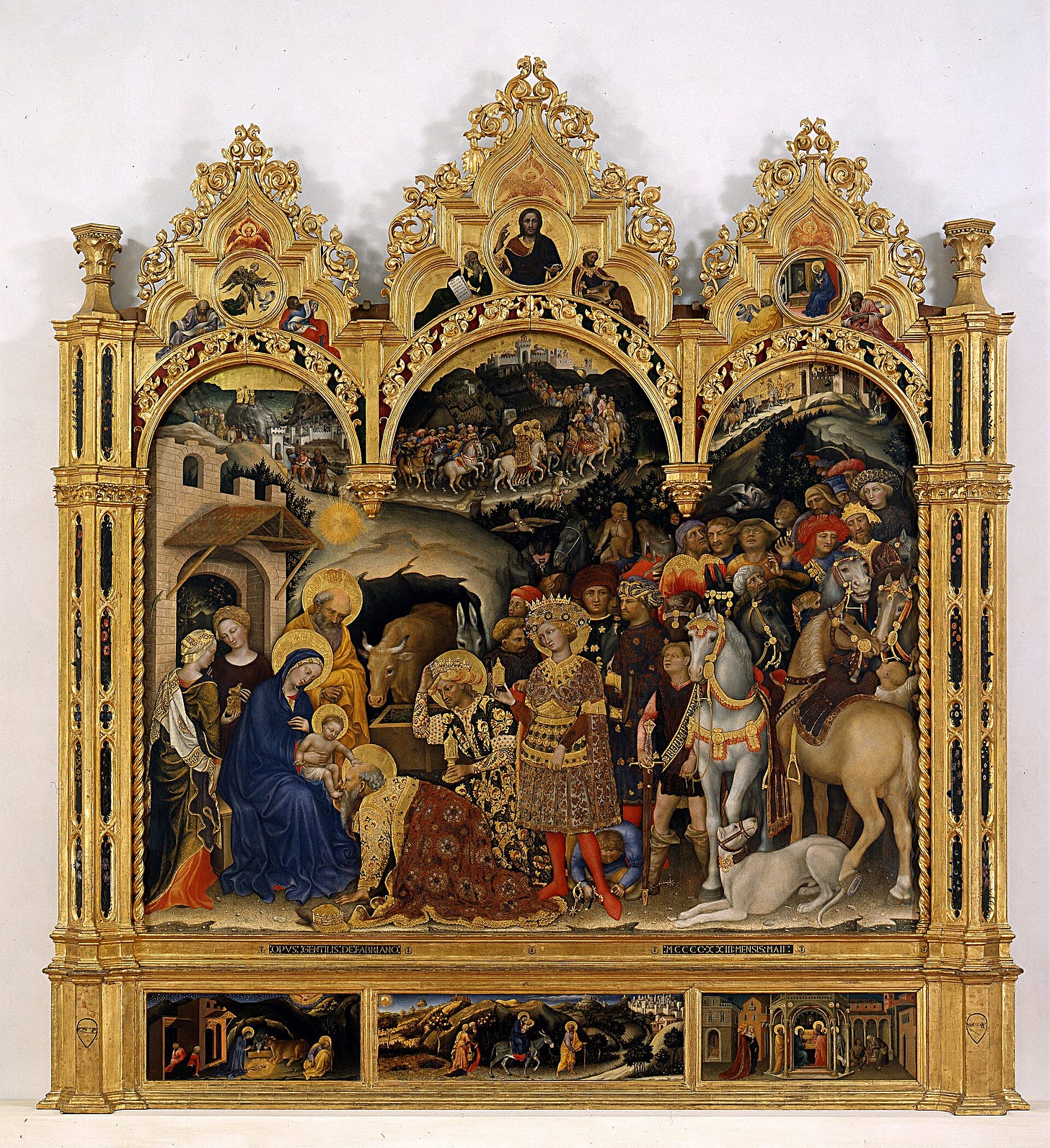 A gold altarpiece under three pointed arches: the Virgin and Child sit at the left before a stable, three crowned kings kneel and bow, and a long courtly procession of riders, horses and animals winds down from the hills behind them.