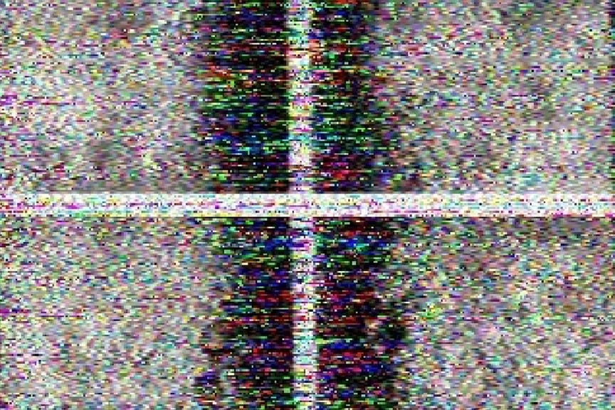 Pixelated, rainbow-speckled image with vertical and horizontal bands, showing heavy visual distortion resembling static; result of a Moonbounce radio transmission of a lunar flag image.