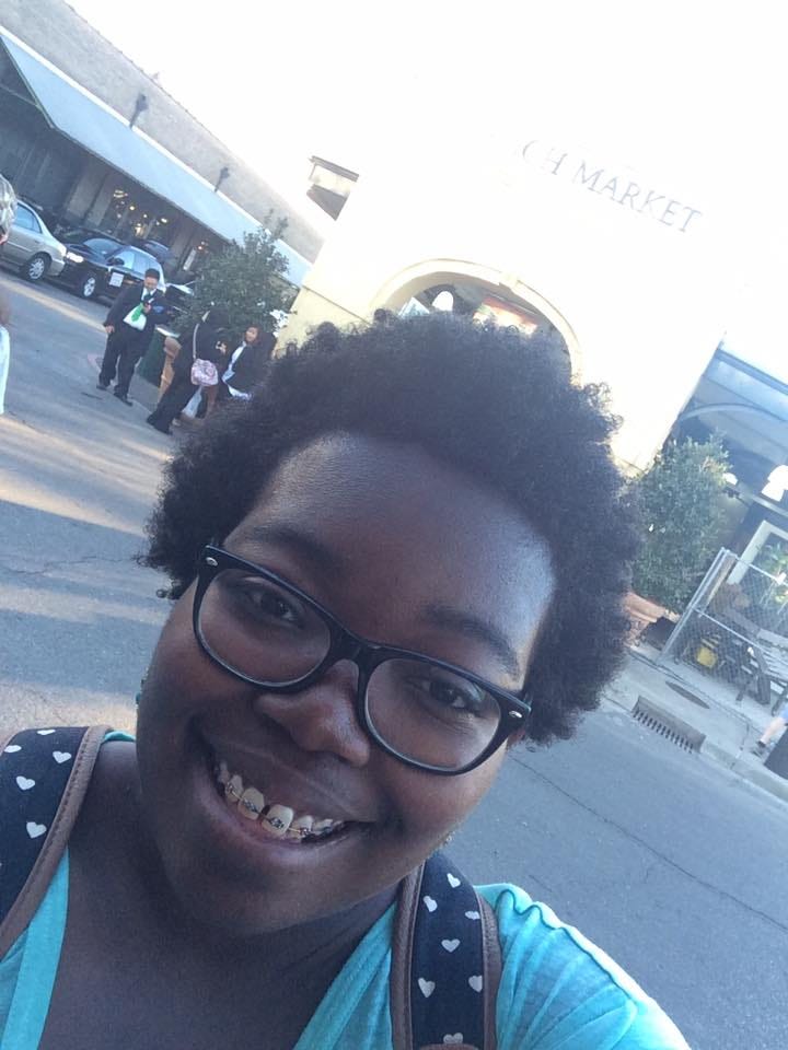 Top row: Jasmine wearing a mask in a shop, a photo of the French Market. Bottom row: a selfie of Jasmine in front of the French market, a photo of Decatur written on the street.