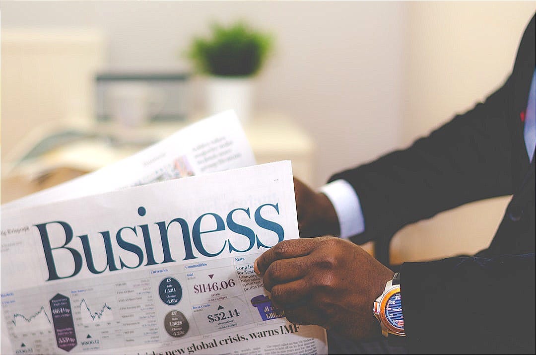 person wearing suit reading business newspaper person wearing suit reading business newspaper