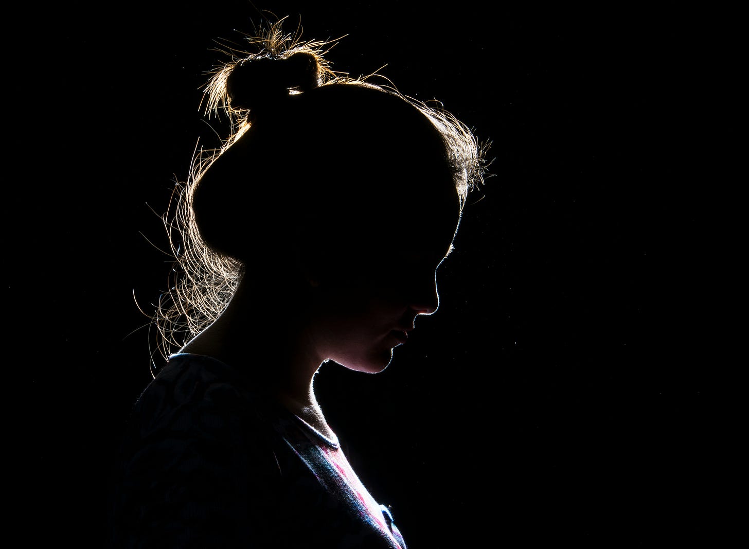 Silouette of woman's head, hair in bun