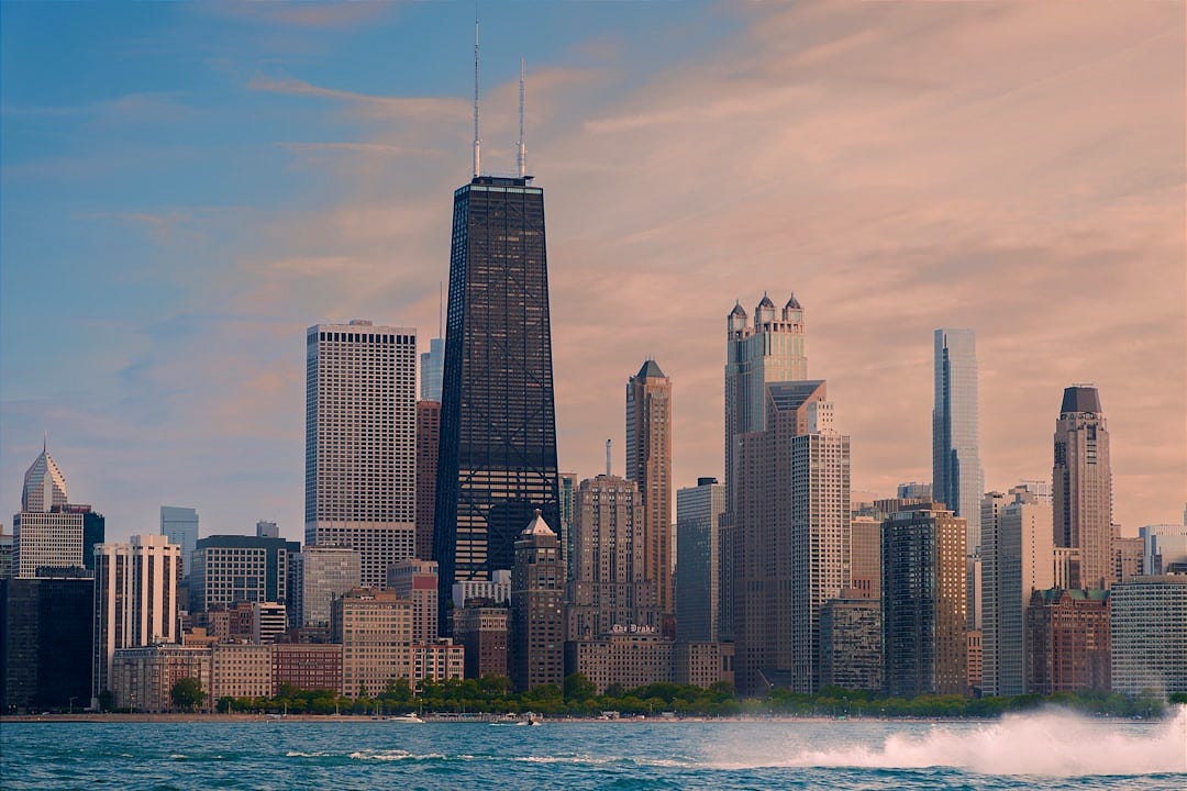 A jet skis across a body of water in front of a large city A jet skis across a body of water in front of a large city