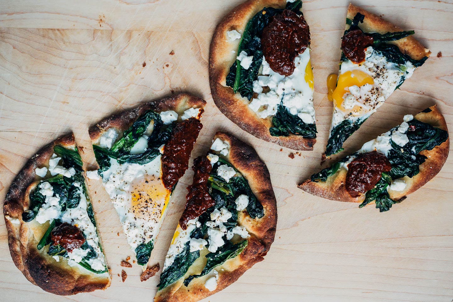 Spinach and feta flatbreads sliced on a cutting board