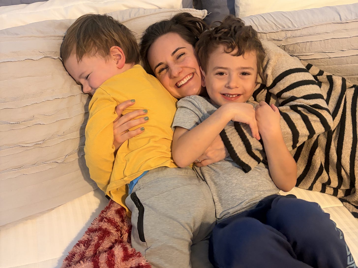 A mom snuggling with her two sons