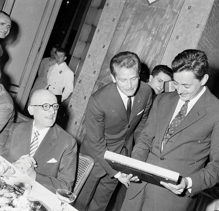 Umberto Agnelli with Juventus officials at a 1950s banquet featuring club crests and commemorative presentations.