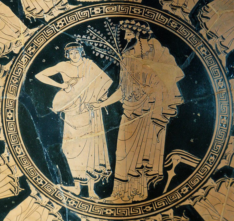 Image of part of a vase with painting of bearded male figure wearing a garland of leaves and holding a two-handled cup. A smaller, beardless male figure fill the cup from a jug.