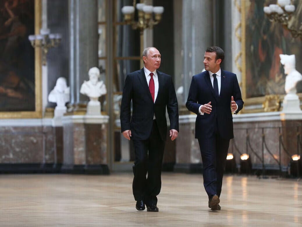 Vladimir Putin y Emmanuel Macron, conversando en un palacio