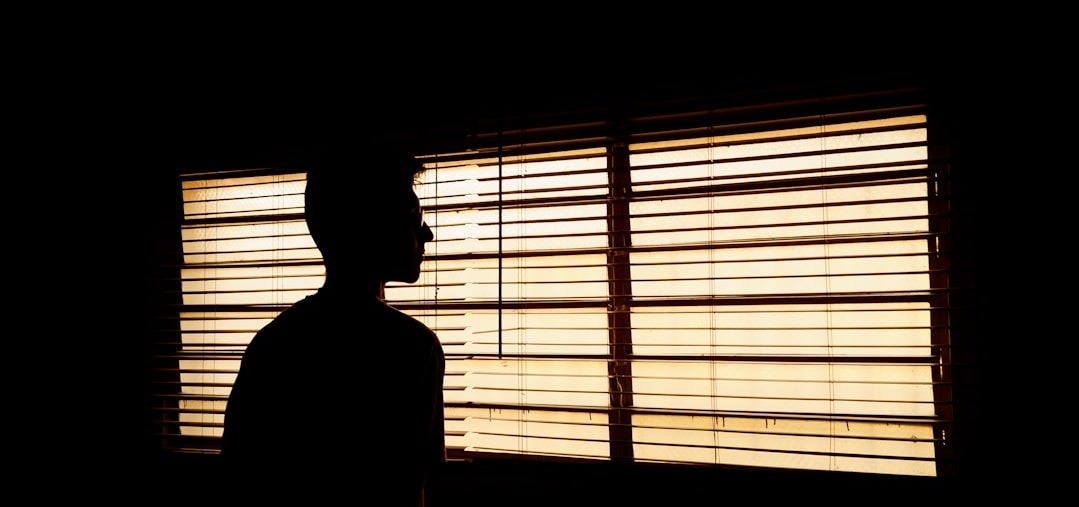 silhouette of person standing near window silhouette of person standing near window