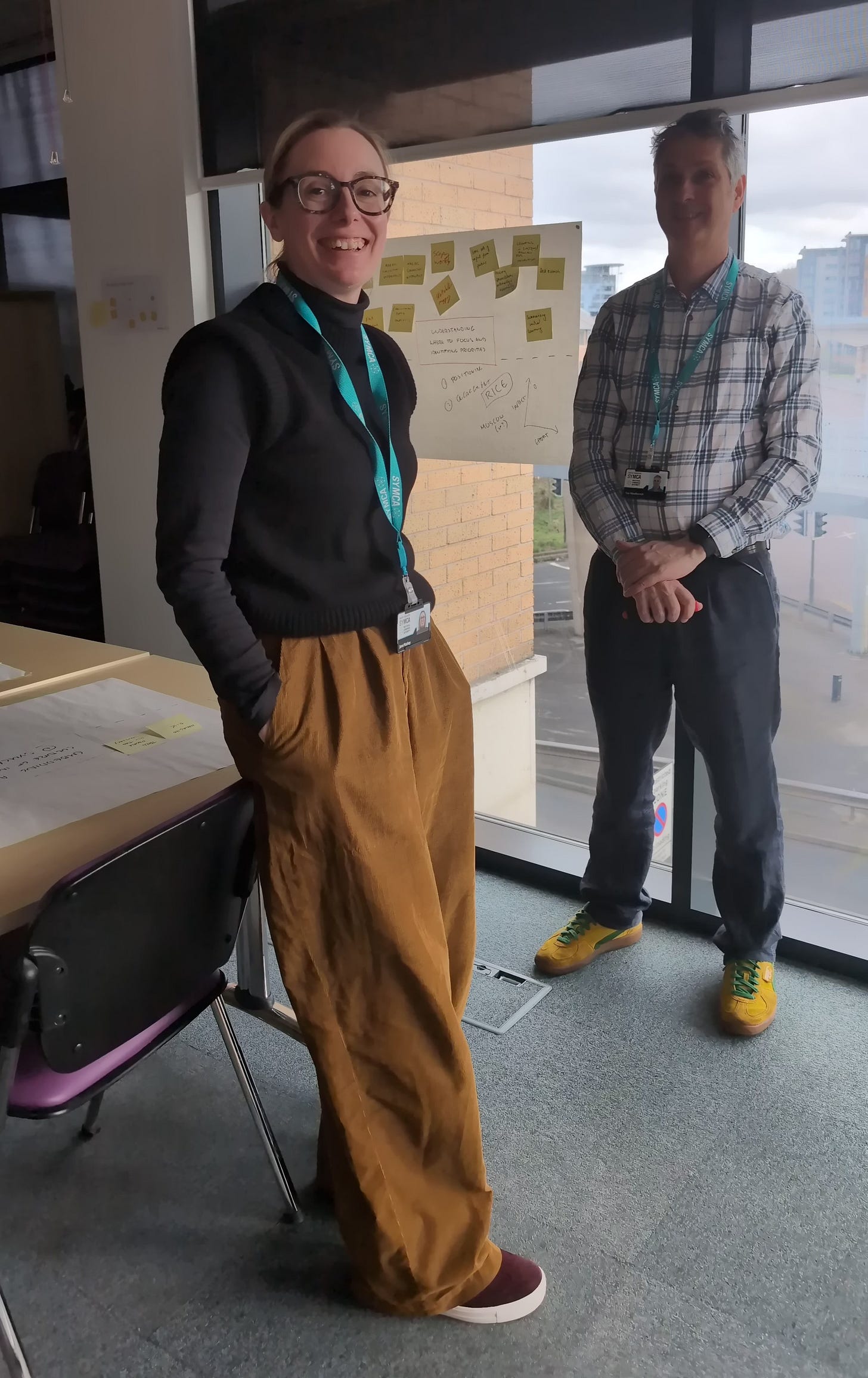Jane Mackey and Tim Woolliscroft from the SYMCA innovation team in front of a window and flip chart paper during a session about the team's roles and responsibilities