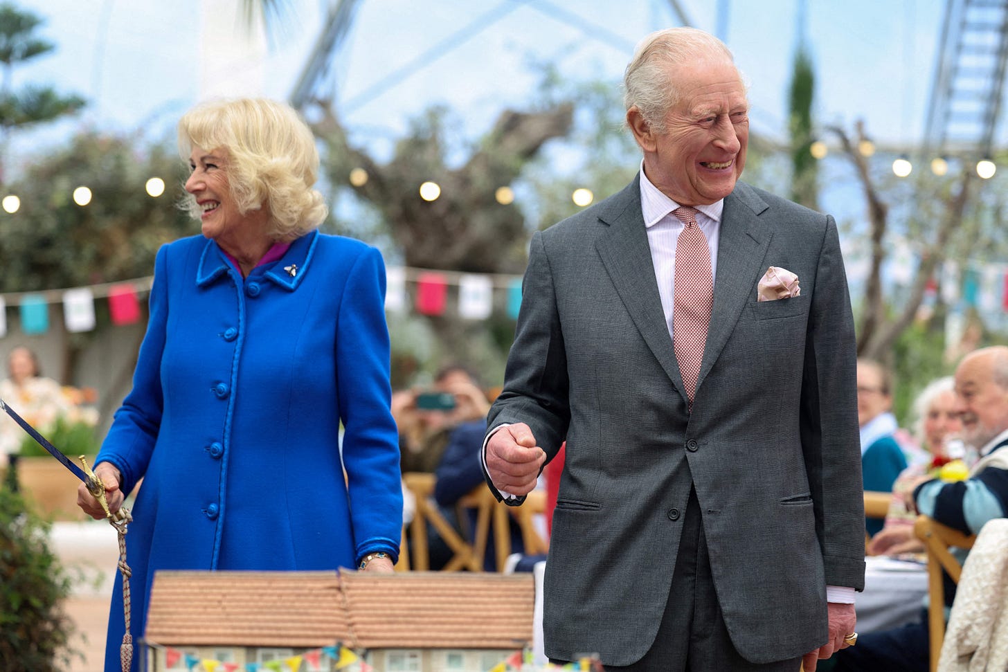 Queen Camilla and King Charles looking away from each other laughing Queen Camilla and King Charles looking away from each other laughing