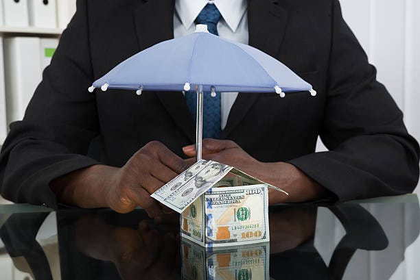 Businessman Protecting House With Umbrella Close-up Of Businessman Hands Protecting House Of Banknote With Umbrella At Desk asset protection practice stock pictures, royalty-free photos & images Businessman Protecting House With Umbrella Close-up Of Businessman Hands Protecting House Of Banknote With Umbrella At Desk asset protection practice stock pictures, royalty-free photos & images