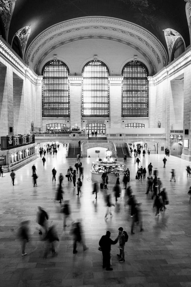 A large building with many people with Grand Central Terminal in the background

Description automatically generated