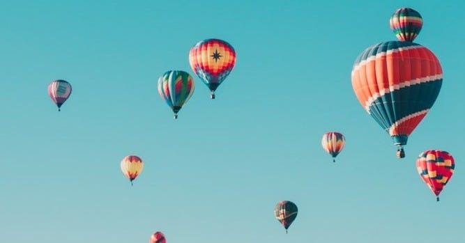 assorted hot air balloons flying at high altitude during daytime assorted hot air balloons flying at high altitude during daytime