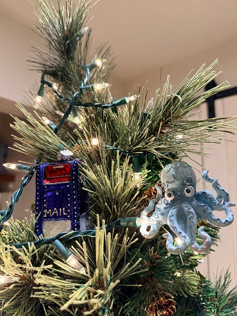 A photo of Meg's Christmas tree, featuring a mailbox ornament, an octopoidal ornament, and a photo of Andrea & Meg at the top.