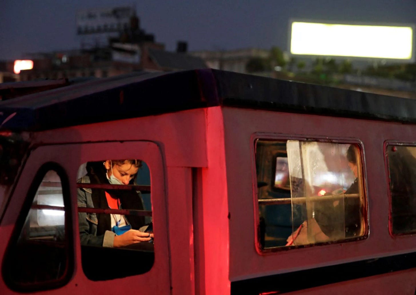 A woman wearing a protective face mask uses her mobile phone inside a public transport vehicle, amidst the outbreak of the coronavirus disease (COVID-19), in Lalitpur, Nepal December 27, 2020. REUTERS/Navesh Chitrakar