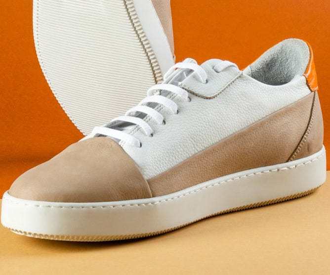 a pair of white and brown shoes on a table