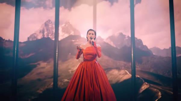 A person in a red dress singing into a microphone

AI-generated content may be incorrect.
