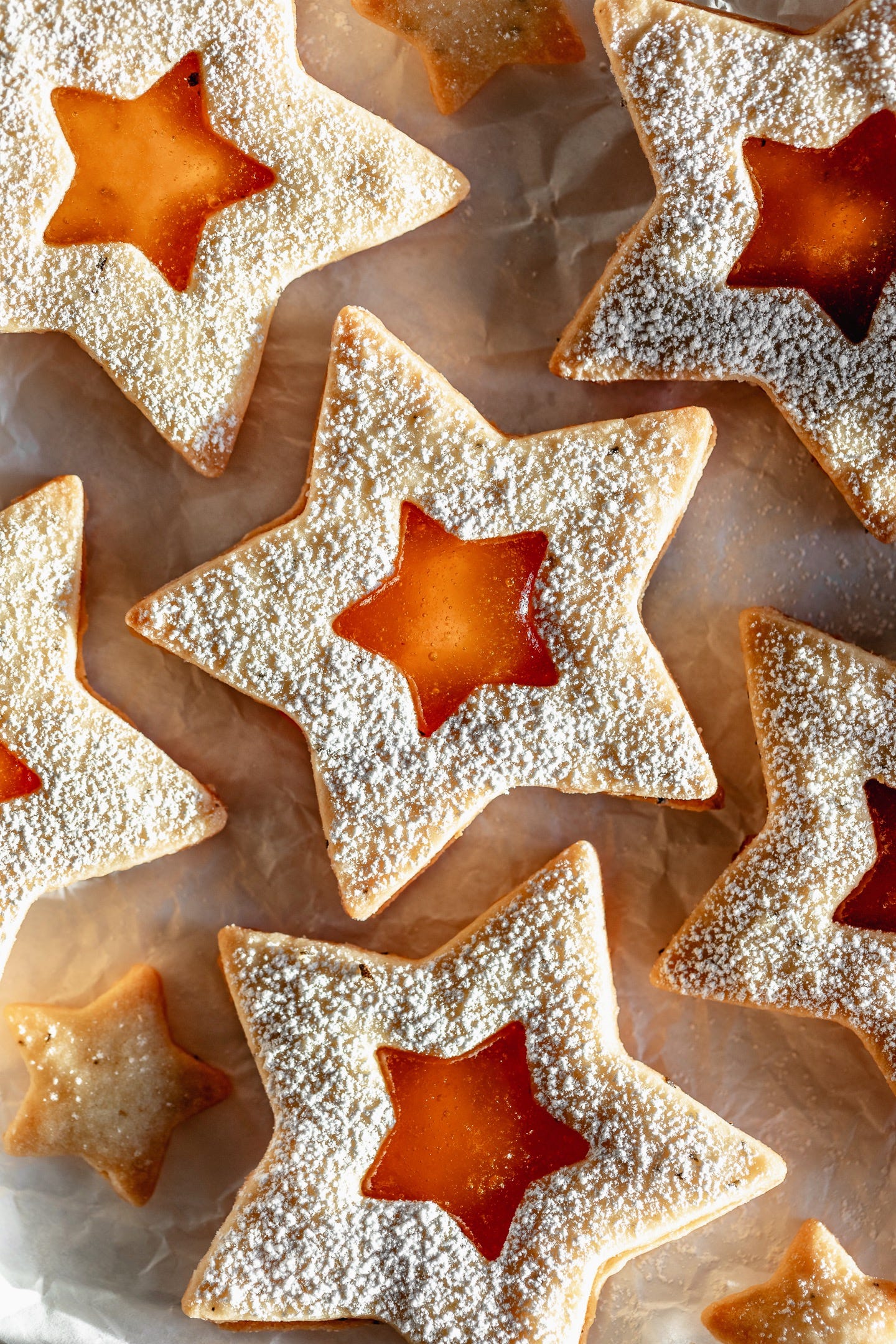 Vegan apricot rosemary linzer stars on parchment paper Vegan apricot rosemary linzer stars on parchment paper