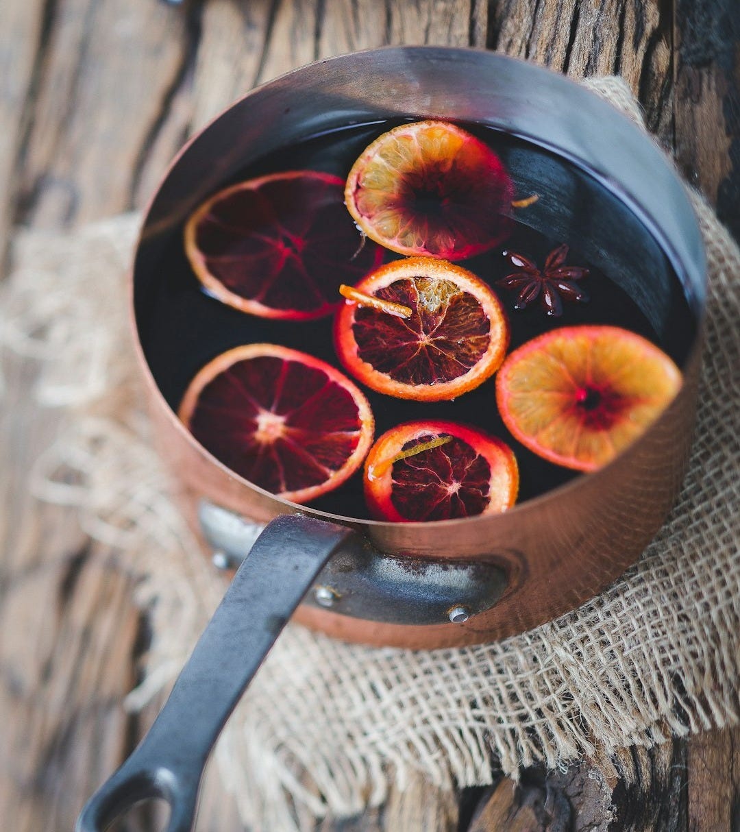 close-up photography of sliced orange fruit on brown cooking pot