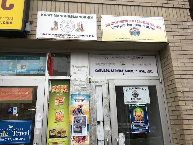 a building entrance with signs in various languages around it. a building entrance with signs in various languages around it.