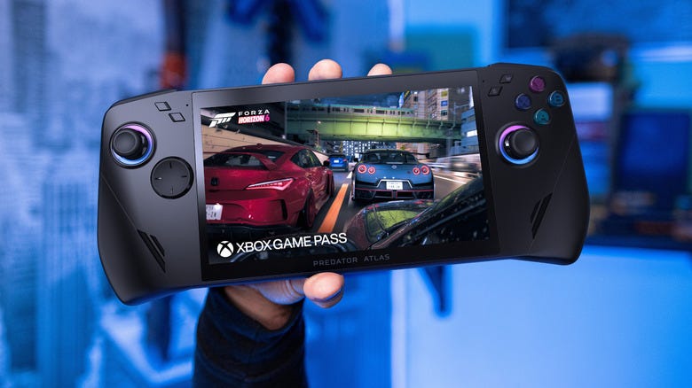 A hand holding a gaming handheld device aloft A hand holding a gaming handheld device aloft