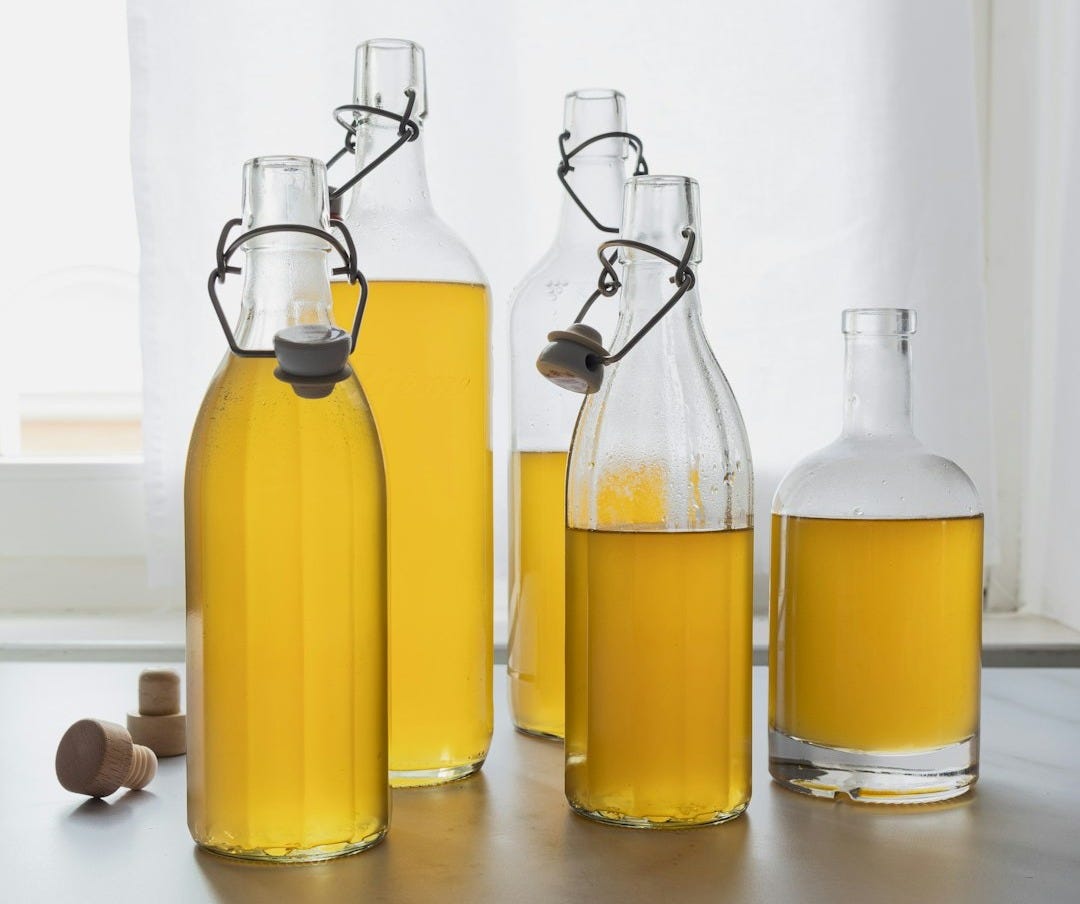 A group of bottles filled with yellow liquid