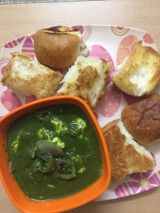 A pink and white plate has 6 pieces of pav with an orange bowl of palak paneer. A pink and white plate has 6 pieces of pav with an orange bowl of palak paneer.
