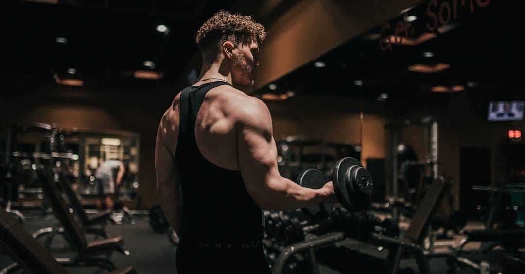a man holding a dumbbell in a gym