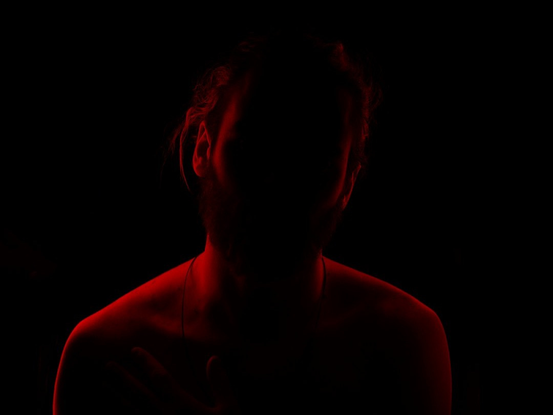 a woman in a dark room with a red light a woman in a dark room with a red light