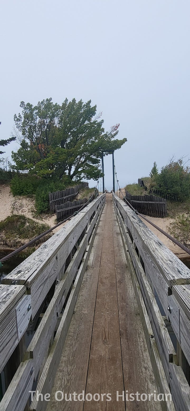 An image of a sign and an image of a wooden suspension bridge designed for foot traffic.