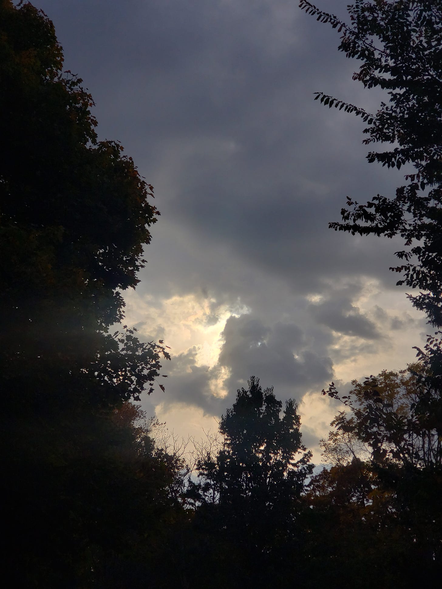 Image is of a dark and stormy day, the clouds heavy with rain, but the light of the sun trying to peek through. Image is of a dark and stormy day, the clouds heavy with rain, but the light of the sun trying to peek through.